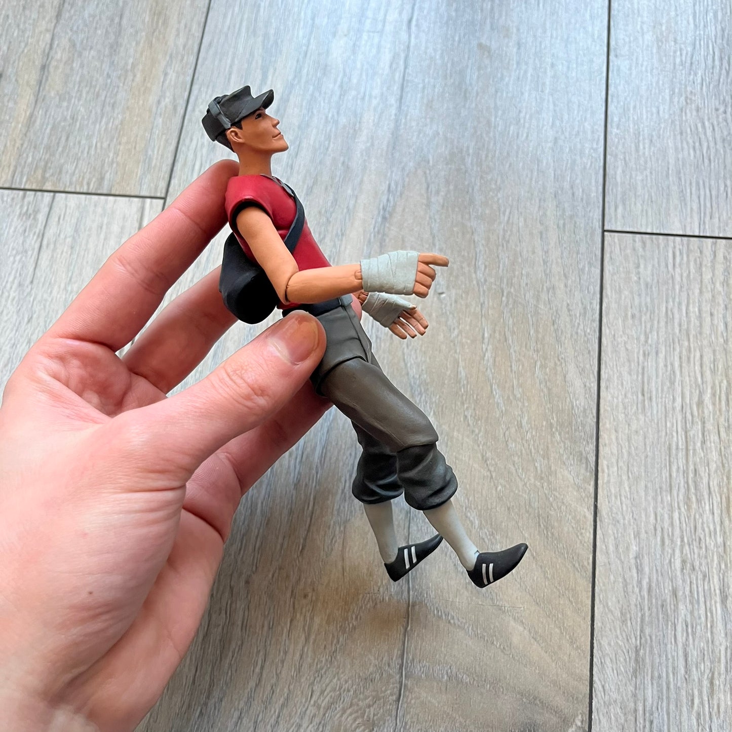 NECA Team Fortress 2 RED Scout Series 4 action figure from 2018. The figure measures approximately 7 inches in scale and recreates the Scout character from Valve’s Team Fortress 2 with game-accurate styling. It features more than 25 points of articulation and comes with three weapons: a scattergun, pistol, and bat.