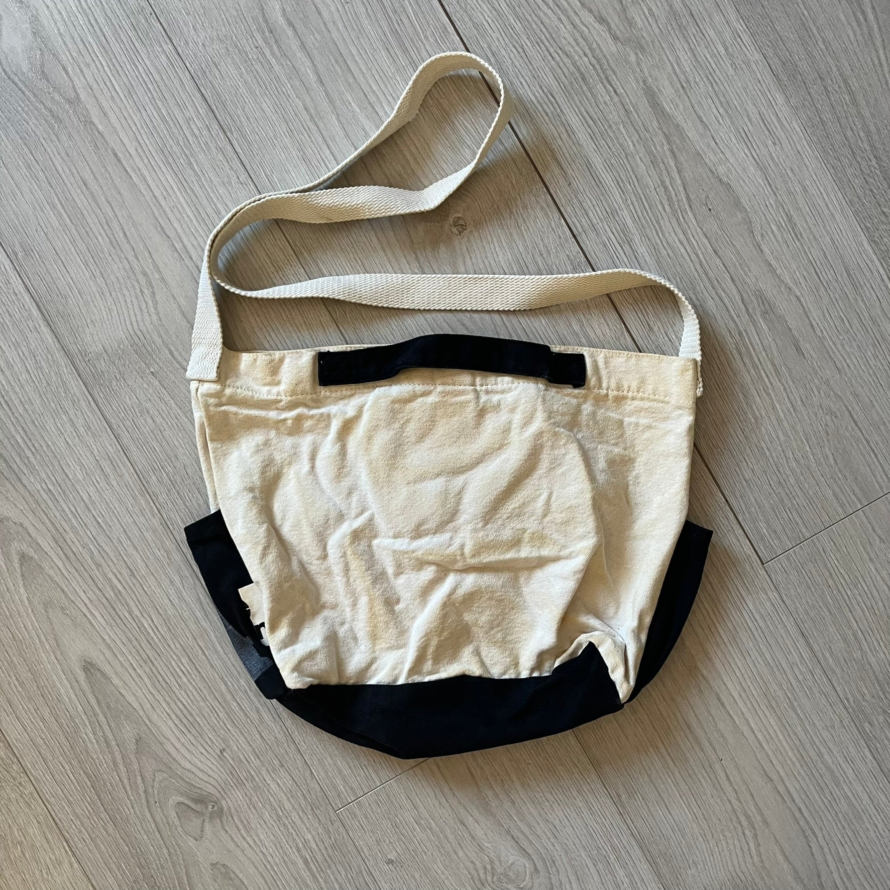 Beige and black bag on a wooden floor