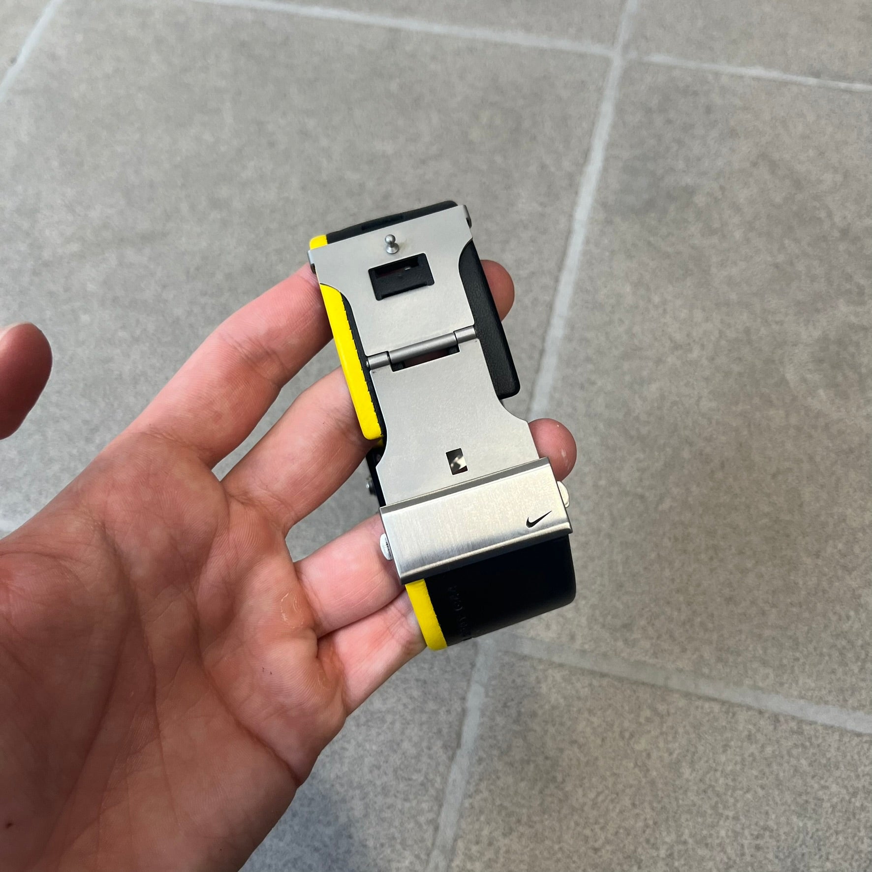 Nike 10//2 Lance Armstrong 2005 Signature Digital Watch features a black stainless steel case with a black LCD display and a black waterproof leather strap with a bright yellow accent. It has a 100-hour chronograph, interval timer, three time alarms, hydration alarm, and data recall, with water resistance to 100 meters. The strap has engraved date and time markings, and the watch comes with the original box and papers.
