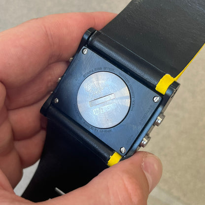 Nike 10//2 Lance Armstrong 2005 Signature Digital Watch features a black stainless steel case with a black LCD display and a black waterproof leather strap with a bright yellow accent. It has a 100-hour chronograph, interval timer, three time alarms, hydration alarm, and data recall, with water resistance to 100 meters. The strap has engraved date and time markings, and the watch comes with the original box and papers.
