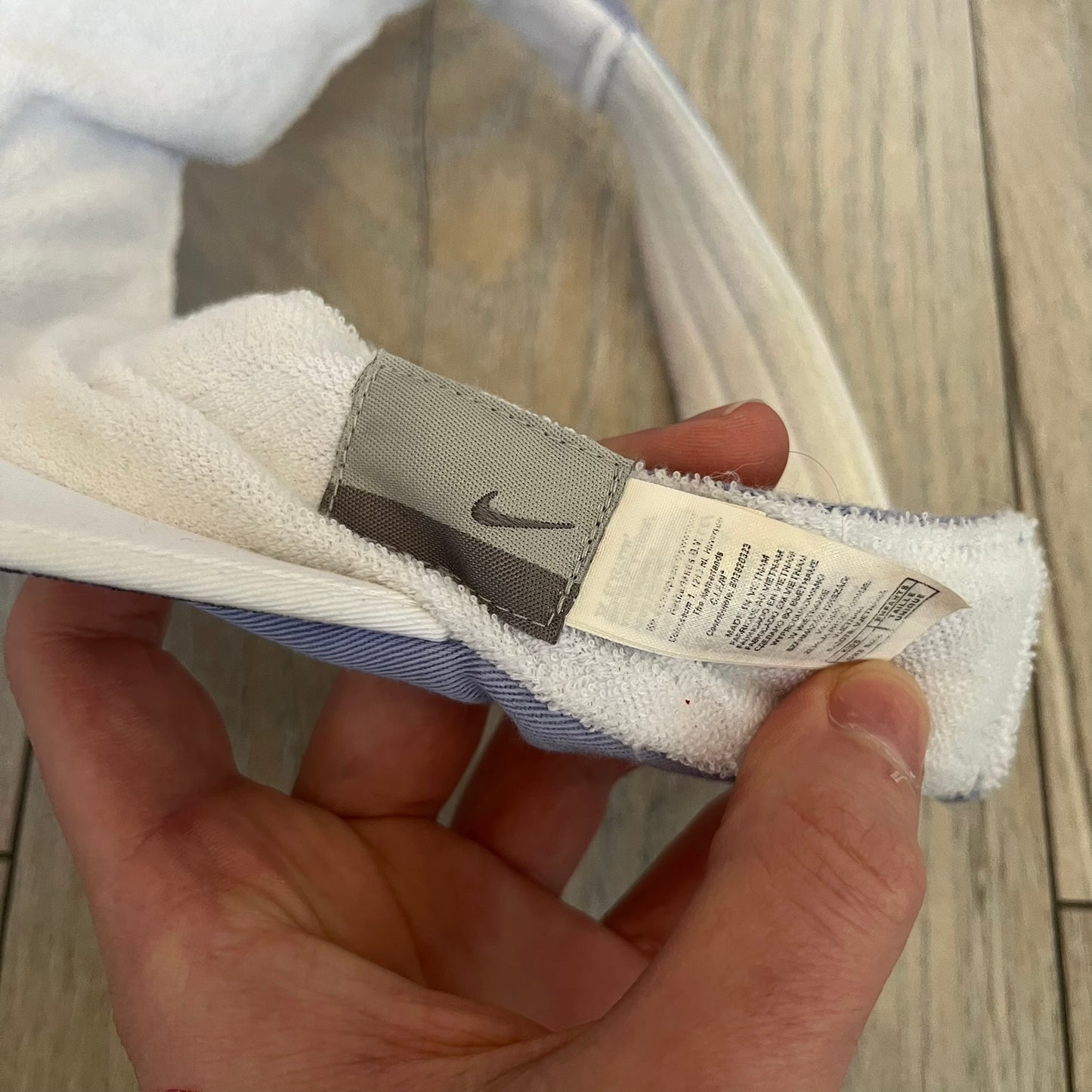 Nike 2000s Violet &amp; White Tennis Visor is a youth-size visor cap featuring a violet crown with white trim running along the edge. The front includes a purple and white Nike logo, while the underside of the brim is finished in white. The visor is designed with a soft, comfortable headband-style strap for a secure fit.