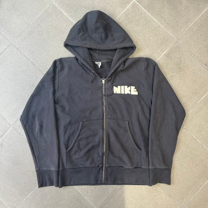 Nike 2010’s Big Logo Black Hoodie is a limited-edition black washed zip hoodie made in Portugal, with a white Nike logo on the chest and a larger one across the upper back, both non-standard designs. It has a standard zipper and a neck tag styled after Nike’s 1980s tags, and the whole piece is finished to look vintage.
