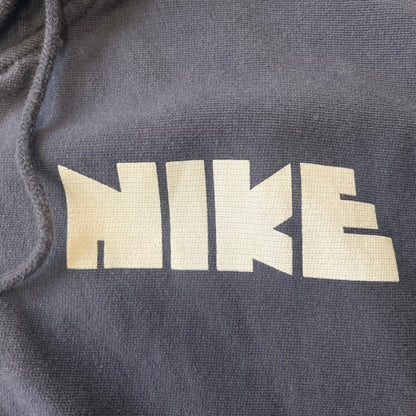 Nike 2010’s Big Logo Black Hoodie is a limited-edition black washed zip hoodie made in Portugal, with a white Nike logo on the chest and a larger one across the upper back, both non-standard designs. It has a standard zipper and a neck tag styled after Nike’s 1980s tags, and the whole piece is finished to look vintage.