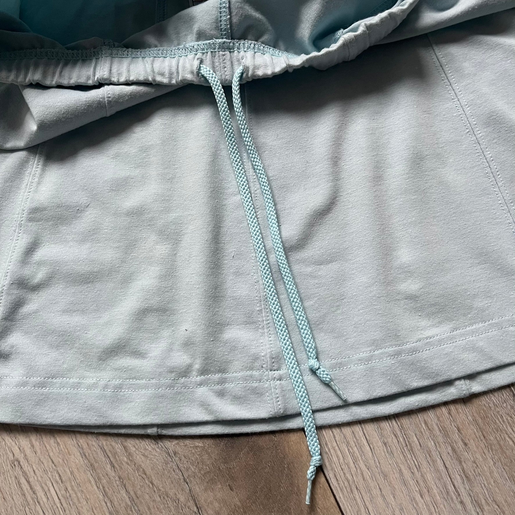 Nike 90’s Challenge Court Tennis Skirt is a baby blue women’s tennis skirt made in Thailand. It features a small green and red Nike Court logo patch at the lower hem, a Dri-FIT patch at the top, and an adjustable waistband with drawstrings.&nbsp;