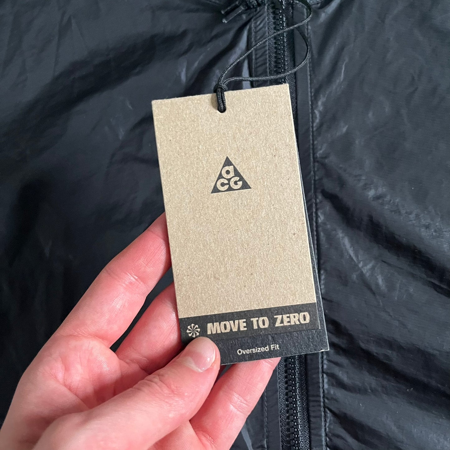 Nike ACG “Cinder Cone” Windbreaker in black, crafted from 100% recycled nylon ripstop. Features a lightweight, water-repellent shell, half-zip closure, and extended collar for added coverage. Designed with no shoulder seams for mobility and finished with printed ACG chest branding, two zippered pockets, and an internal baby carabiner.