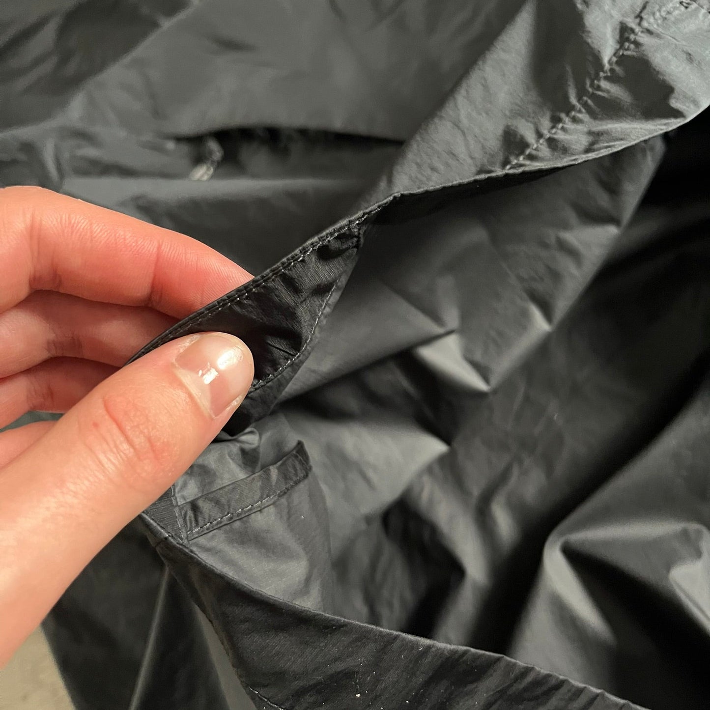 Nike ACG “Cinder Cone” Windbreaker in black, crafted from 100% recycled nylon ripstop. Features a lightweight, water-repellent shell, half-zip closure, and extended collar for added coverage. Designed with no shoulder seams for mobility and finished with printed ACG chest branding, two zippered pockets, and an internal baby carabiner.