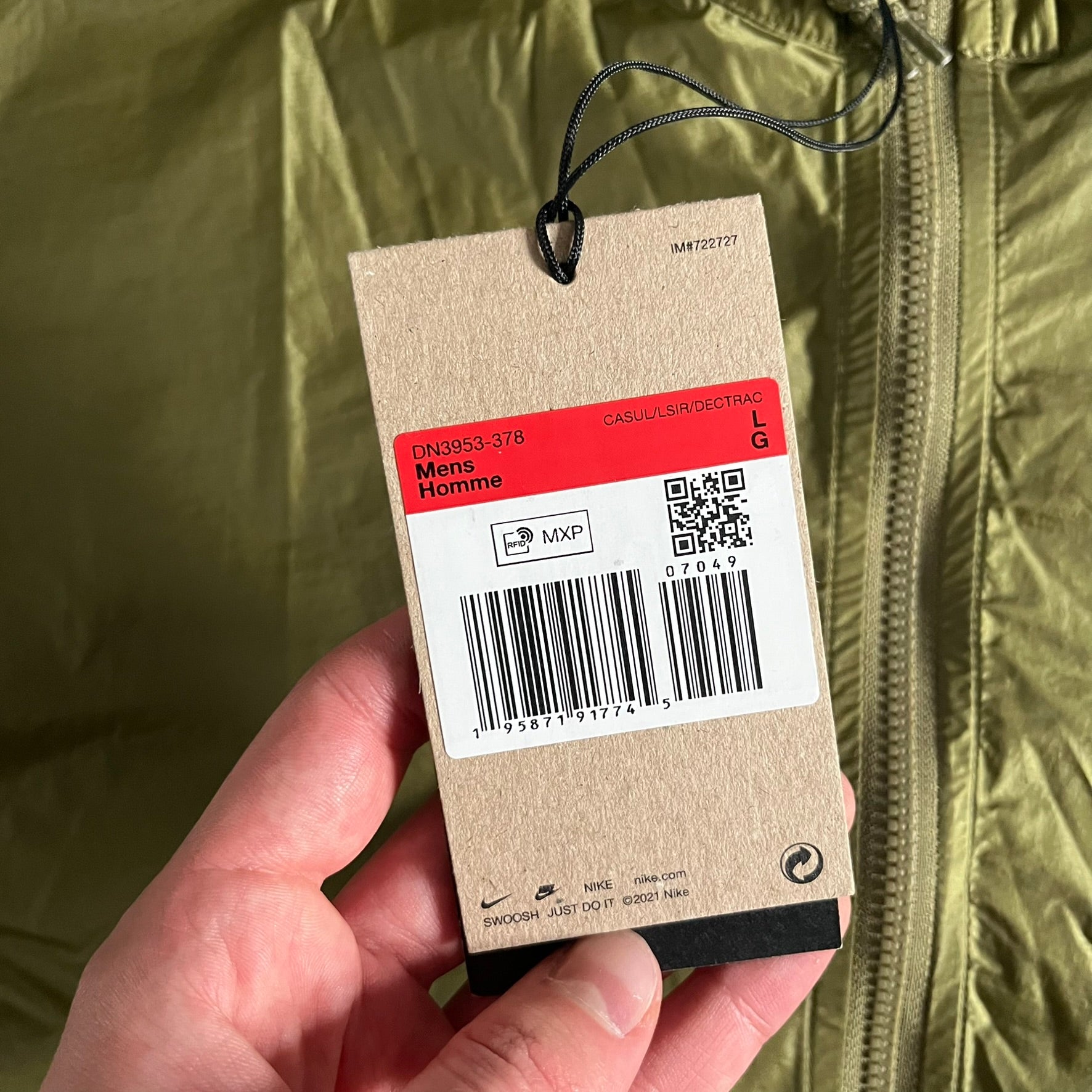 Olive Nike ACG Cinder Cone 1/2 Zip Jacket made from durable nylon ripstop with water-repellent finish. Designed with no shoulder seams for mobility, elastic cuffs, reinforced hem, and two zip pockets. Includes printed chest logo and internal ACG carabiner, with packable oversized construction.