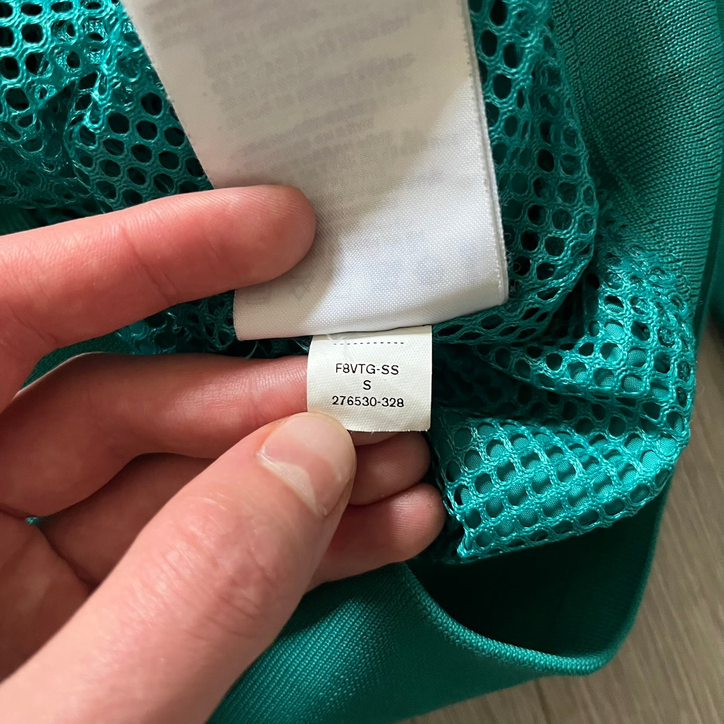 Nike 2008 Australia Olympics Split Windbreaker in teal, detailed with yellow star embroidery inspired by Australia’s national emblem. Designed with double side zippers that let the jacket separate for modular wear. Includes embroidered white Nike logo on the chest and Australian flag details inside both pockets.