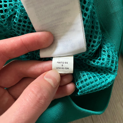 Nike 2008 Australia Olympics Split Windbreaker in teal, detailed with yellow star embroidery inspired by Australia’s national emblem. Designed with double side zippers that let the jacket separate for modular wear. Includes embroidered white Nike logo on the chest and Australian flag details inside both pockets.