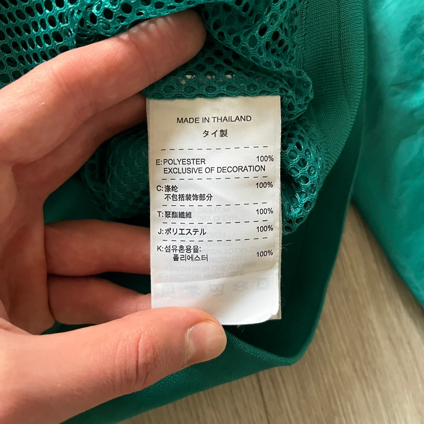 Nike 2008 Australia Olympics Split Windbreaker in teal, detailed with yellow star embroidery inspired by Australia’s national emblem. Designed with double side zippers that let the jacket separate for modular wear. Includes embroidered white Nike logo on the chest and Australian flag details inside both pockets.