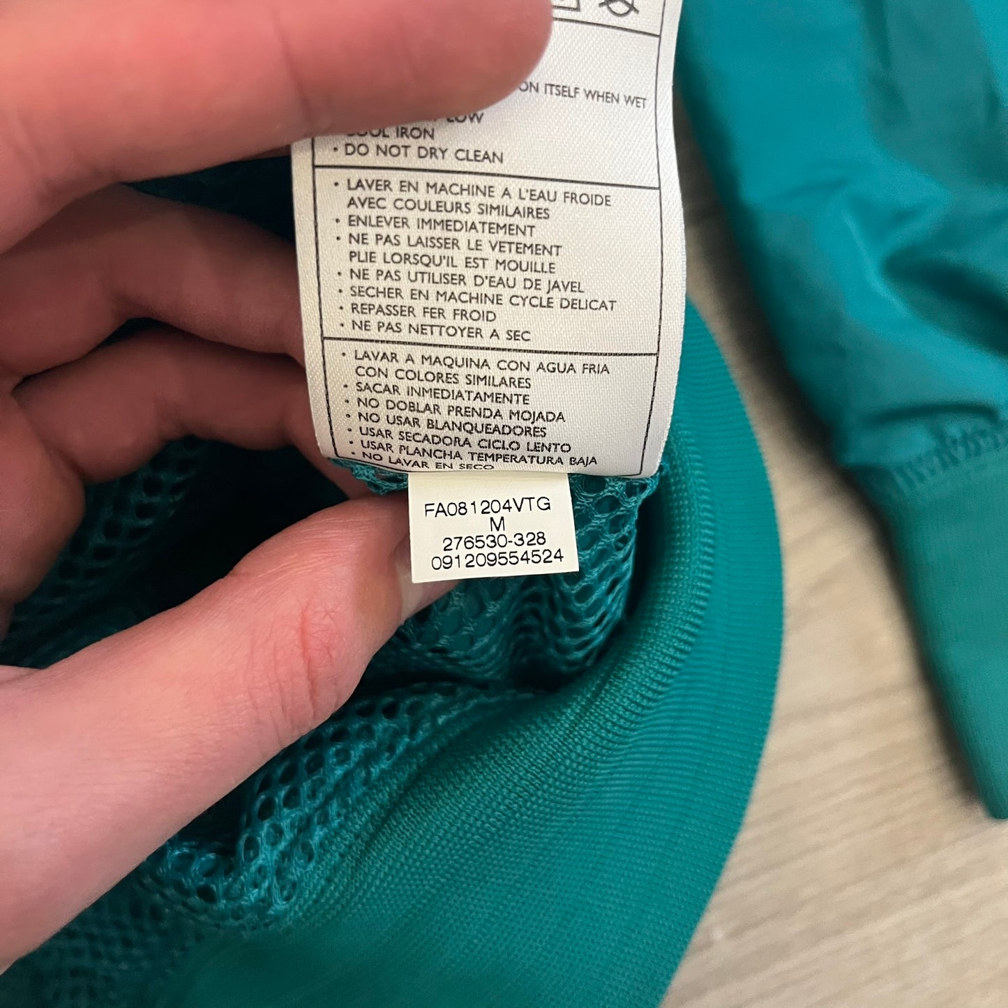 Nike 2008 Australia Olympics Split Windbreaker in teal, detailed with yellow star embroidery inspired by Australia’s national emblem. Designed with double side zippers that let the jacket separate for modular wear. Includes embroidered white Nike logo on the chest and Australian flag details inside both pockets.