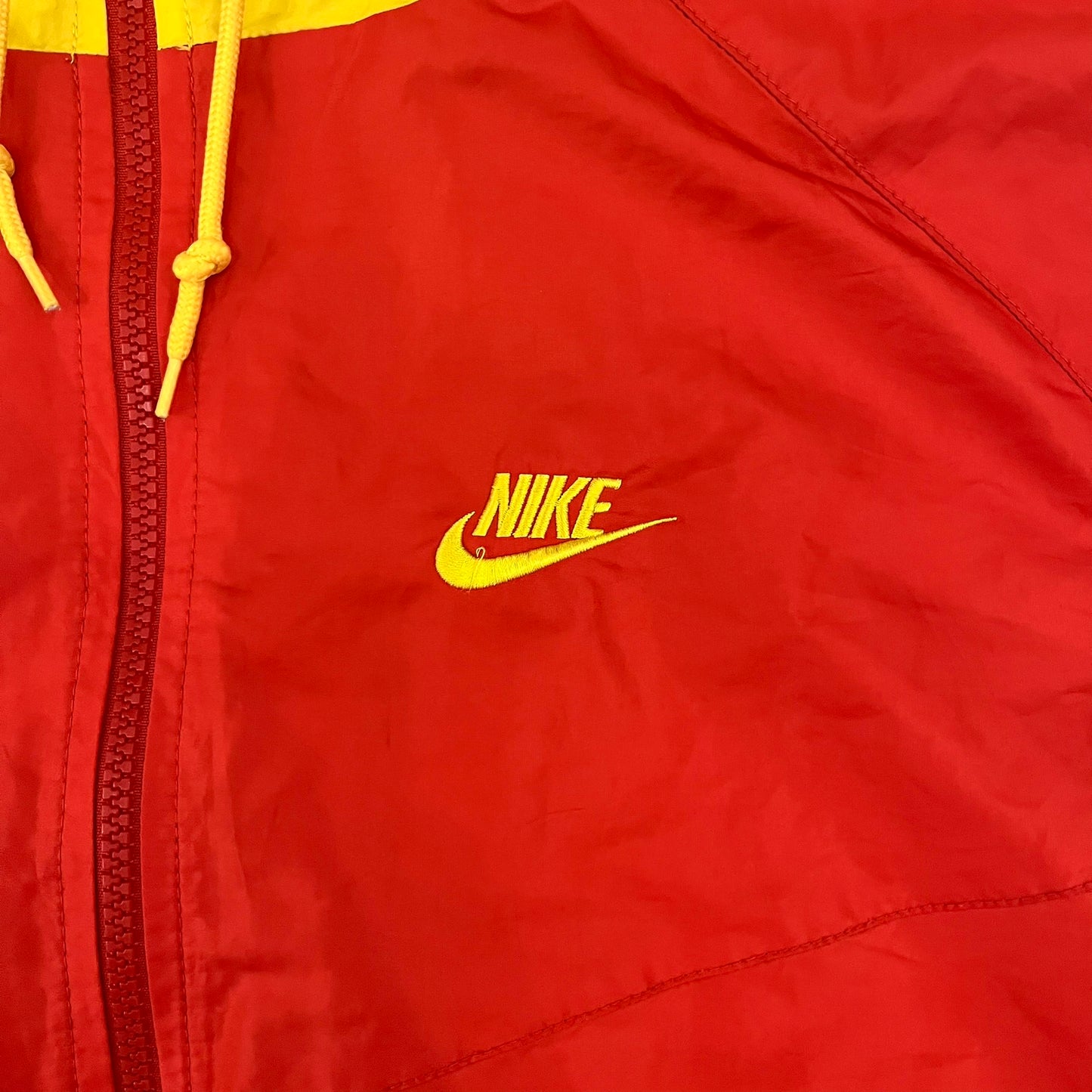 Nike China Olympics Split Windbreaker from 2008, crafted in red with a yellow hood representing China colors. This innovative jacket can be zipped apart on both sides and merged with other compatible models. This jacket doesn't have typical flags in the pockets.