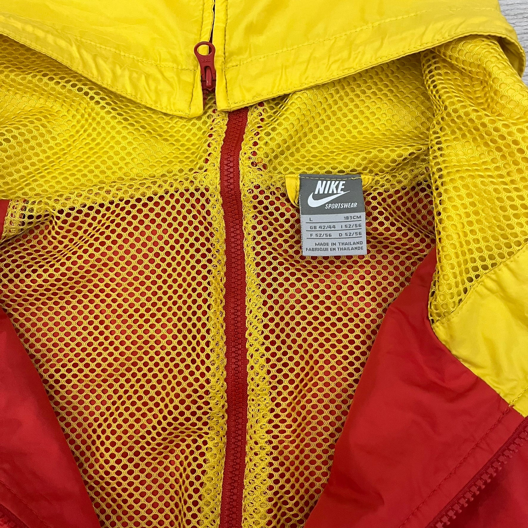 Nike China Olympics Split Windbreaker from 2008, crafted in red with a yellow hood representing China colors. This innovative jacket can be zipped apart on both sides and merged with other compatible models. This jacket doesn't have typical flags in the pockets.