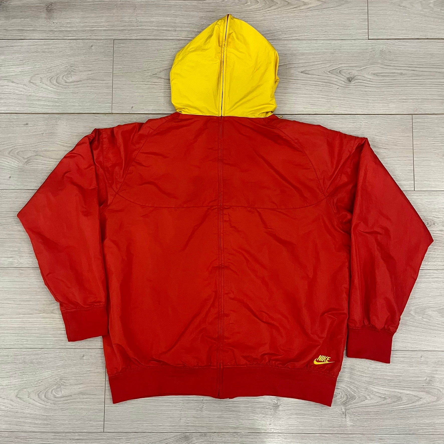 Nike China Olympics Split Windbreaker from 2008, crafted in red with a yellow hood representing China colors. This innovative jacket can be zipped apart on both sides and merged with other compatible models. This jacket doesn't have typical flags in the pockets.