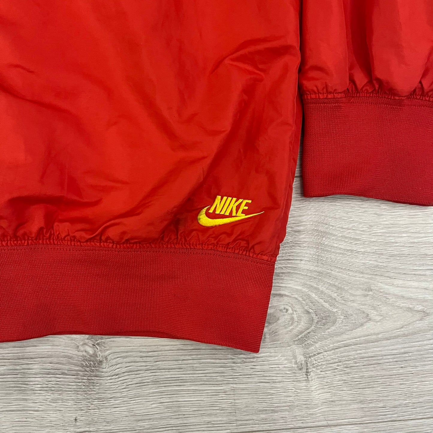 Nike China Olympics Split Windbreaker from 2008, crafted in red with a yellow hood representing China colors. This innovative jacket can be zipped apart on both sides and merged with other compatible models. This jacket doesn't have typical flags in the pockets.