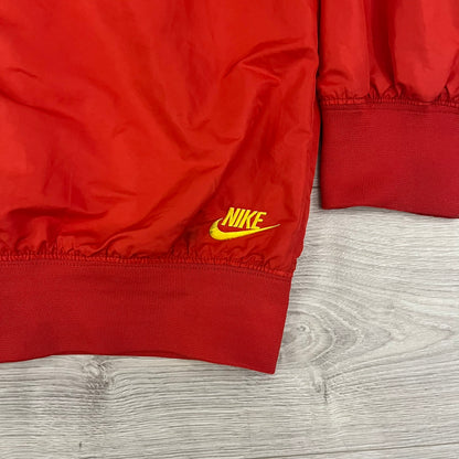 Nike China Olympics Split Windbreaker from 2008, crafted in red with a yellow hood representing China colors. This innovative jacket can be zipped apart on both sides and merged with other compatible models. This jacket doesn't have typical flags in the pockets.