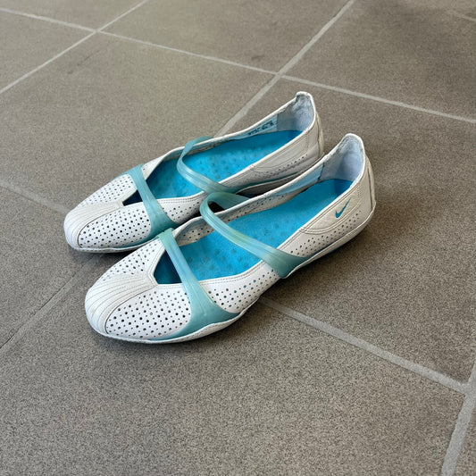 Nike City Knife 3 Barrette 2004 White Flats is a rare, packable hybrid ballet flat and athletic shoe designed by Michael DiTullo, blending a low-profile ballet-flat silhouette with technical mesh and ventilation. The white upper features perforated detailing, a small Nike Swoosh, and blue accents on the rubber top lines, interior, and sole.