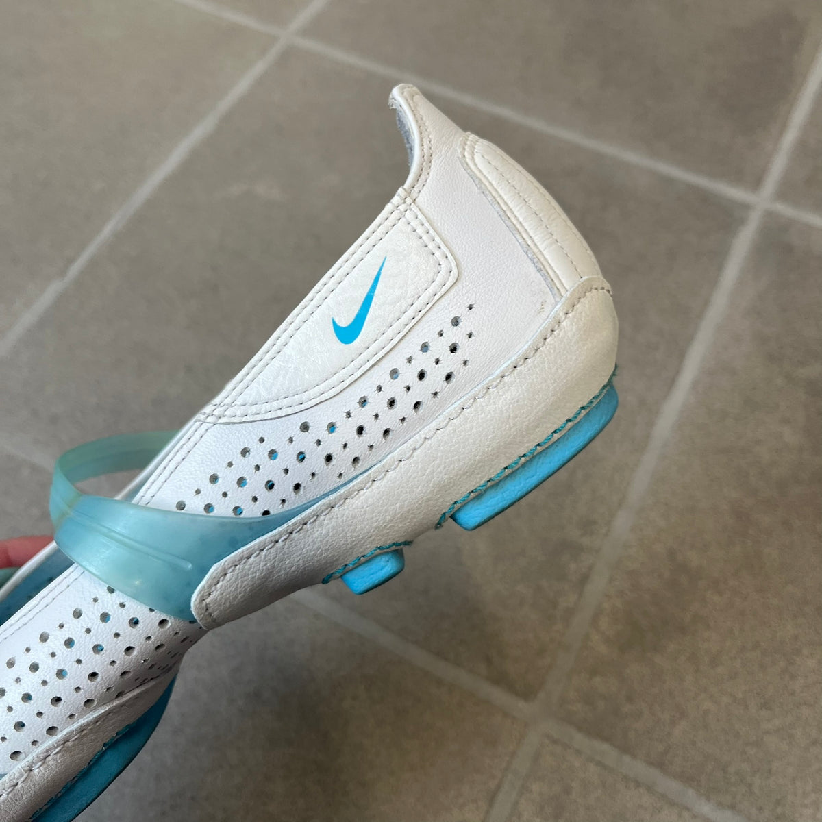 Nike City Knife 3 Barrette 2004 White Flats is a rare, packable hybrid ballet flat and athletic shoe designed by Michael DiTullo, blending a low-profile ballet-flat silhouette with technical mesh and ventilation. The white upper features perforated detailing, a small Nike Swoosh, and blue accents on the rubber top lines, interior, and sole.