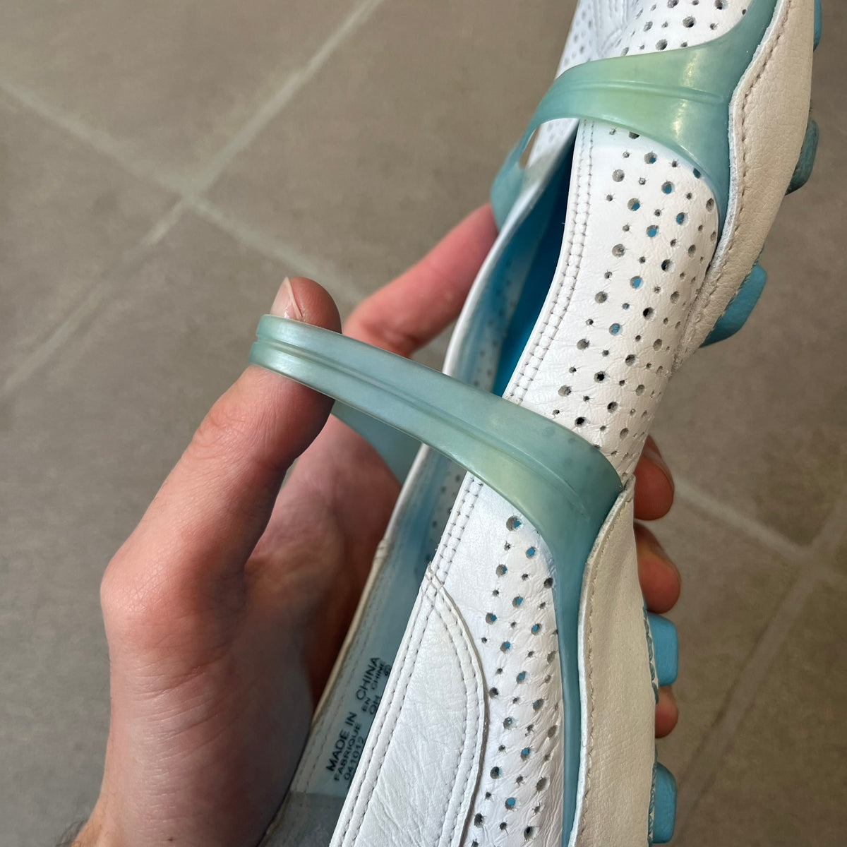 Nike City Knife 3 Barrette 2004 White Flats is a rare, packable hybrid ballet flat and athletic shoe designed by Michael DiTullo, blending a low-profile ballet-flat silhouette with technical mesh and ventilation. The white upper features perforated detailing, a small Nike Swoosh, and blue accents on the rubber top lines, interior, and sole.