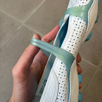 Nike City Knife 3 Barrette 2004 White Flats is a rare, packable hybrid ballet flat and athletic shoe designed by Michael DiTullo, blending a low-profile ballet-flat silhouette with technical mesh and ventilation. The white upper features perforated detailing, a small Nike Swoosh, and blue accents on the rubber top lines, interior, and sole.