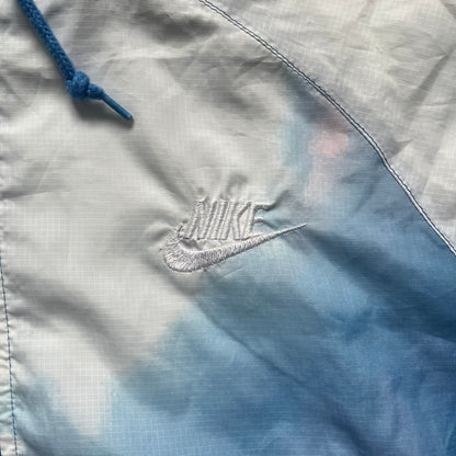 Nike Cloud Day Split Windbreaker from the 2010s in full blue with a photorealistic all-over cloud print. Features dual zippers on the front and back, allowing the jacket to split in half and merge with other compatible pieces. Made from 100% nylon.
