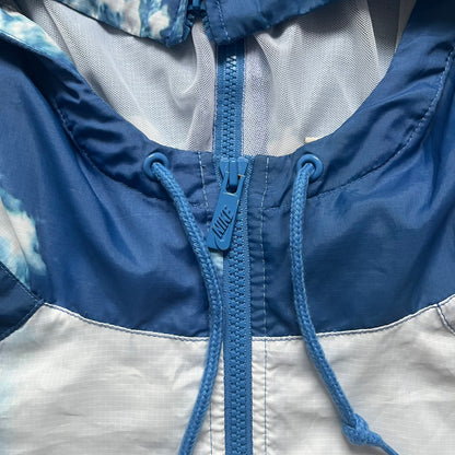 Nike Cloud Day Split Windbreaker from the 2010s in full blue with a photorealistic all-over cloud print. Features dual zippers on the front and back, allowing the jacket to split in half and merge with other compatible pieces. Made from 100% nylon.