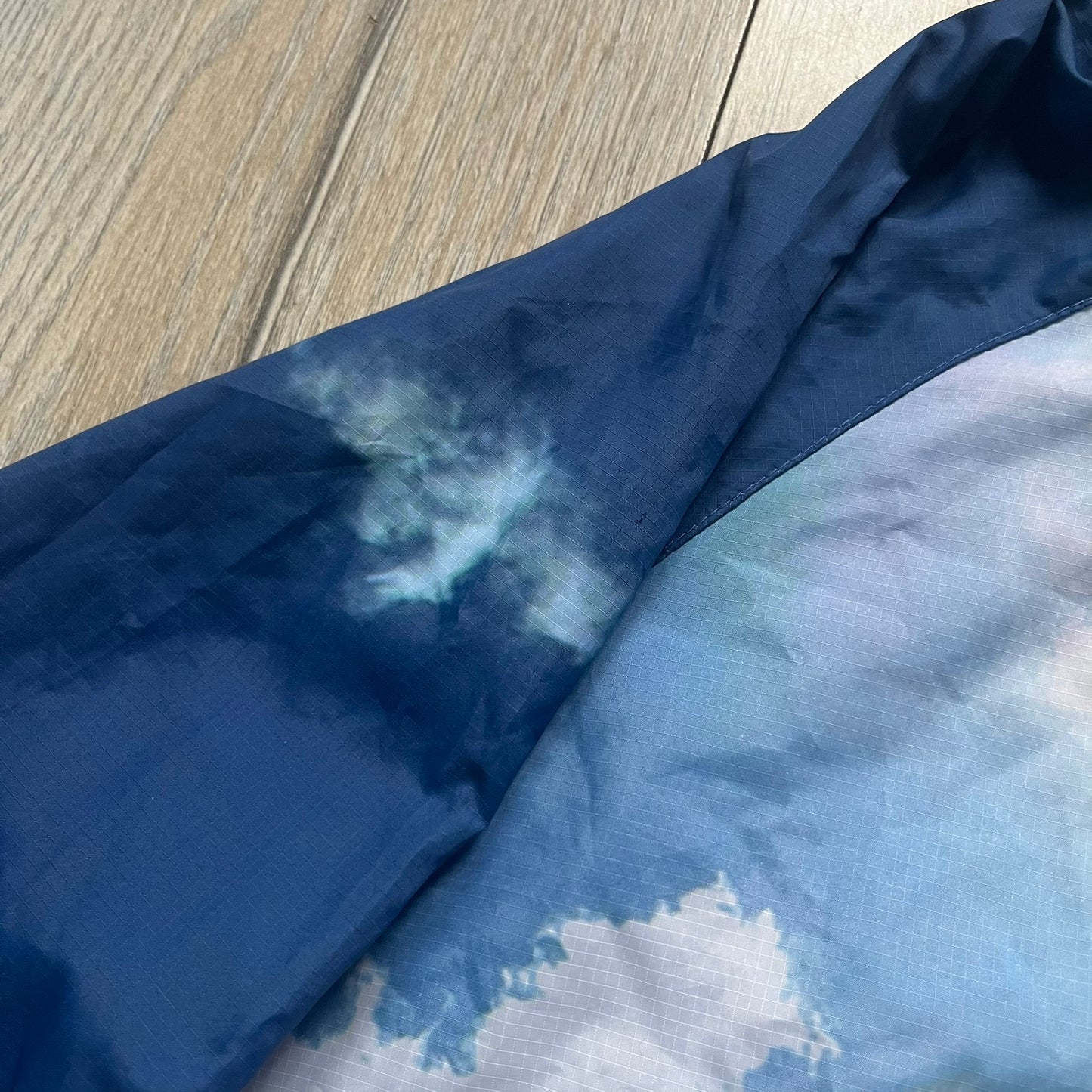 Nike Cloud Day Split Windbreaker from the 2010s in full blue with a photorealistic all-over cloud print. Features dual zippers on the front and back, allowing the jacket to split in half and merge with other compatible pieces. Made from 100% nylon.
