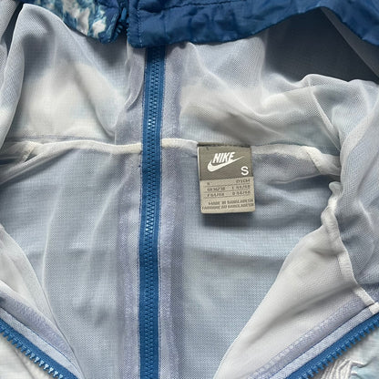 Nike Cloud Day Split Windbreaker from the 2010s in full blue with a photorealistic all-over cloud print. Features dual zippers on the front and back, allowing the jacket to split in half and merge with other compatible pieces. Made from 100% nylon.