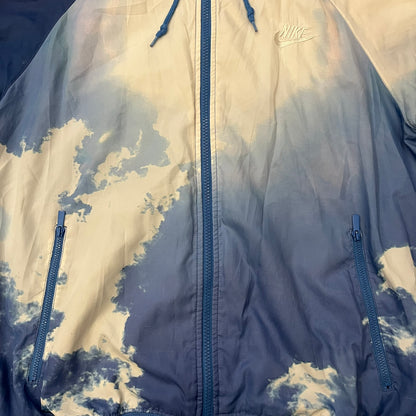 Nike Cloud Day Split Windbreaker from the 2010s in full blue with a photorealistic all-over cloud print. Features dual zippers on the front and back, allowing the jacket to split in half and merge with other compatible pieces. Made from 100% nylon.