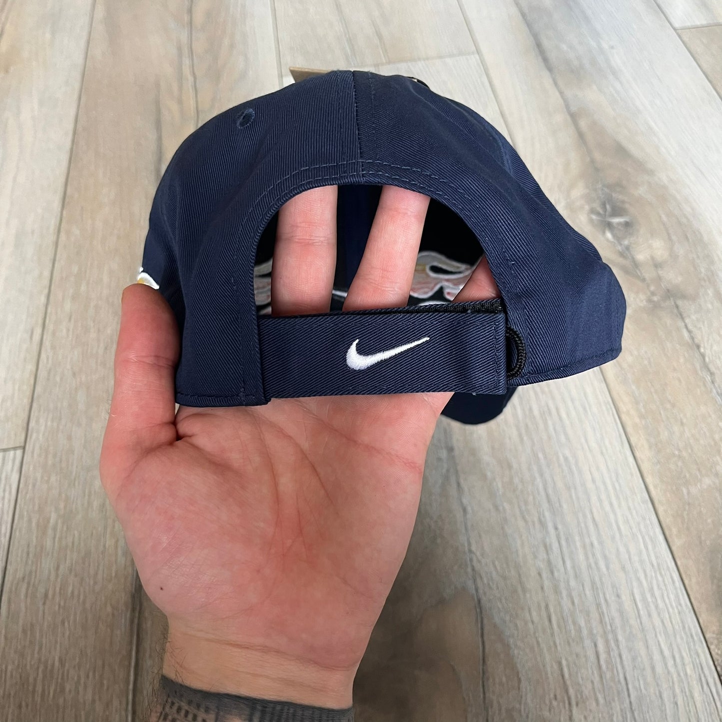 Nike Club Semi-Structured OG Midnight Navy Flame Cap is a navy baseball cap featuring a white Nike Swoosh centered on the front panel. Embroidered flame graphics in orange, yellow, and red extend across the front of the visor and side panels. A small white Nike Swoosh is placed at the back. The design is identified by code IH9258-410.