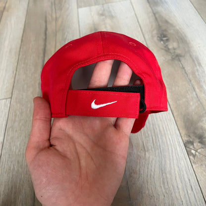 Nike Club Semi-Structured OG University Red Flame Cap is a red baseball cap featuring a white Nike Swoosh centered on the front panel. Embroidered flame graphics in orange, yellow, and red extend across the front of the visor and side panels. A small white Nike Swoosh is placed at the back. The design is identified by code IH9258-657.&nbsp;