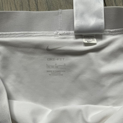 Nike Court Victory Tennis Skirt is a kids’ tennis skort with built-in inner shorts for coverage. The skirt features a textured fabric with fine linear detailing, while the waistband remains smooth, and a black Nike Swoosh is placed at the lower hem. The design includes a pleated section.
