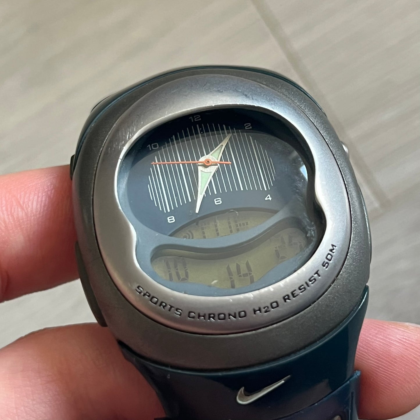 Nike Sports Chrono Cross Training Watch (WX0015) featuring a unique ana-digi “Covert” design with a partial hood over the analog dial. The display combines a three-hand analog setup with a curved dual-section LCD showing time, day, and mode. Water-resistant up to 50m and equipped with chronograph, timer, alarm, and dual-time functions, this model reflects Nike’s peak era of performance-driven digital innovation.