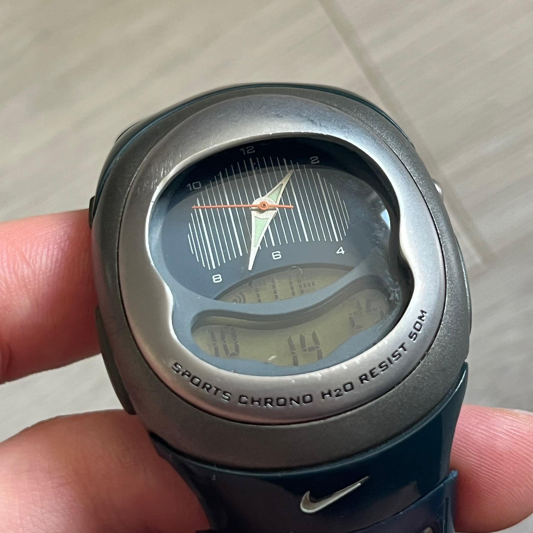 Nike Sports Chrono Cross Training Watch (WX0015) featuring a unique ana-digi “Covert” design with a partial hood over the analog dial. The display combines a three-hand analog setup with a curved dual-section LCD showing time, day, and mode. Water-resistant up to 50m and equipped with chronograph, timer, alarm, and dual-time functions, this model reflects Nike’s peak era of performance-driven digital innovation.