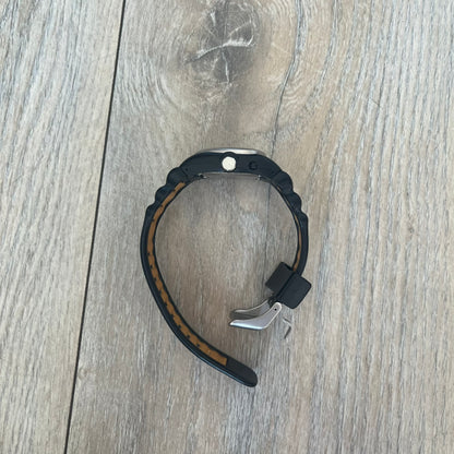 Nike Cross Training VG72-5000 Analog Watch is a 2000s model featuring a black strap, silver-tone stainless steel case, and black dial. The oval-shaped case has a flattened top with an orange Nike Swoosh positioned above the dial. It uses a three-hand analog display and includes an additional button above the crown to operate the backlight.