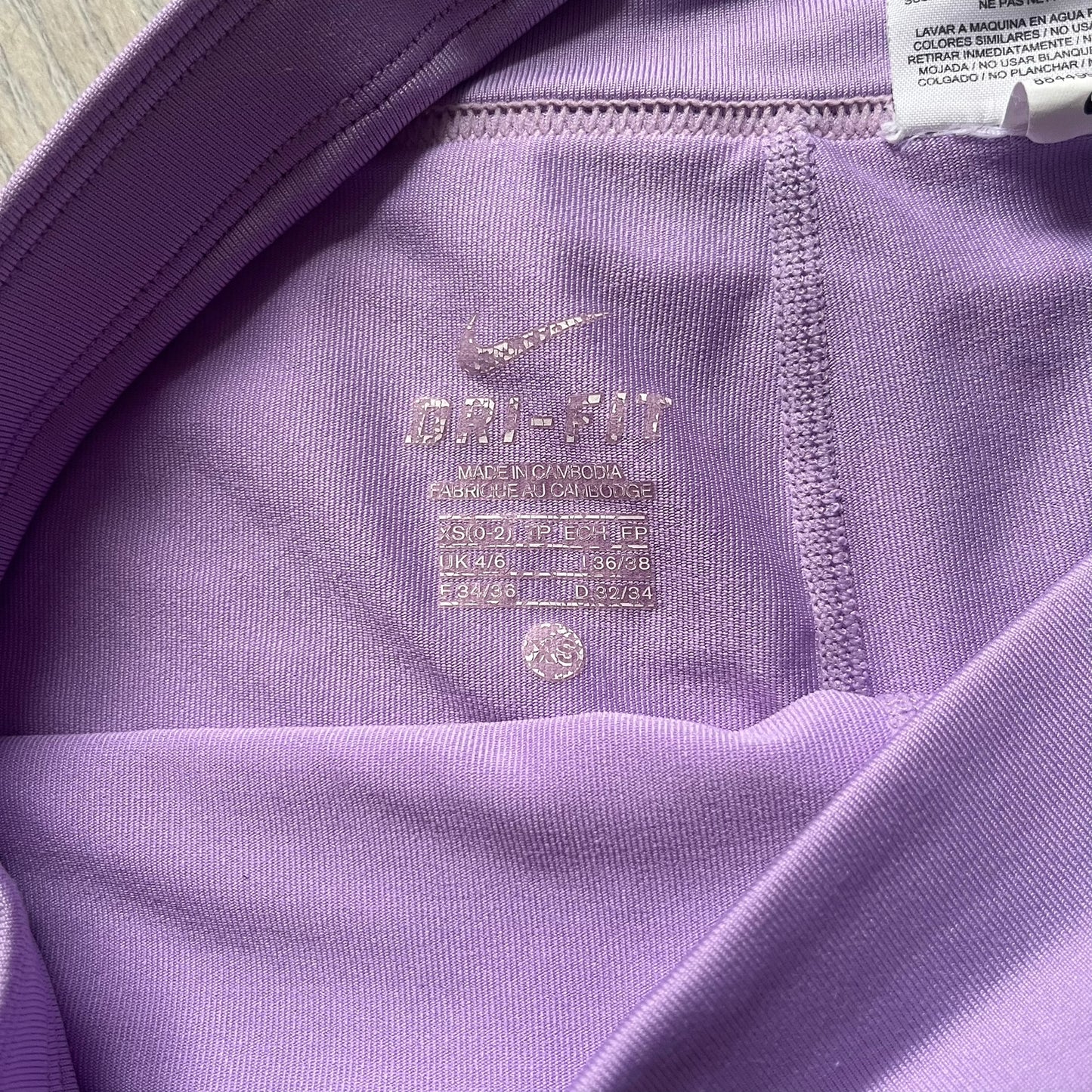 Nike Dri-FIT Striped Lavender Tennis Skirt is a women’s tennis skort with integrated inner shorts for coverage and support. The skirt features diagonal white and lavender stripes on the front and back, a small Nike Court logo on the side, and an embroidered lavender Swoosh at the lower front. The lavender waistband and side cutouts provide comfort and mobility during play.