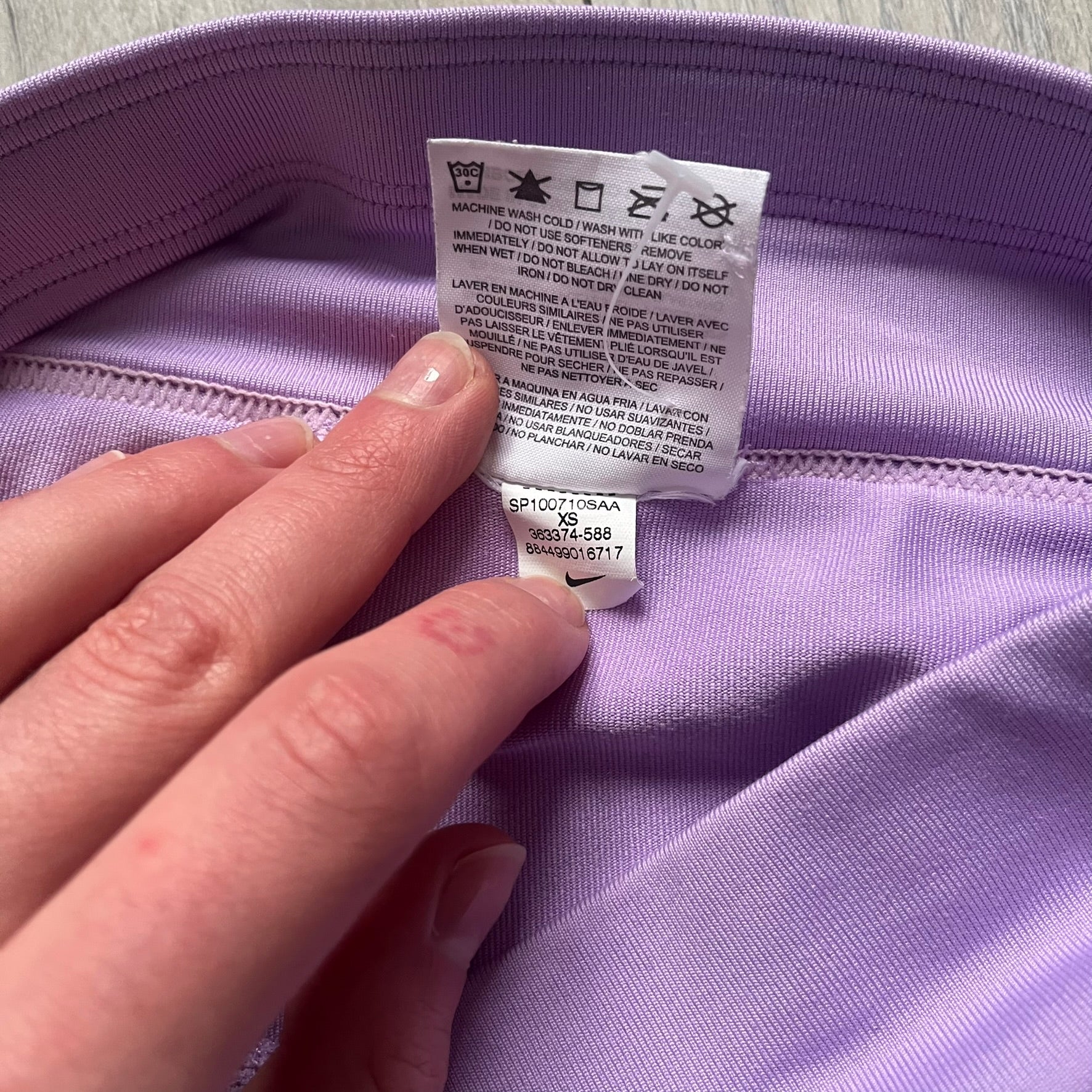 Nike Dri-FIT Striped Lavender Tennis Skirt is a women’s tennis skort with integrated inner shorts for coverage and support. The skirt features diagonal white and lavender stripes on the front and back, a small Nike Court logo on the side, and an embroidered lavender Swoosh at the lower front. The lavender waistband and side cutouts provide comfort and mobility during play.