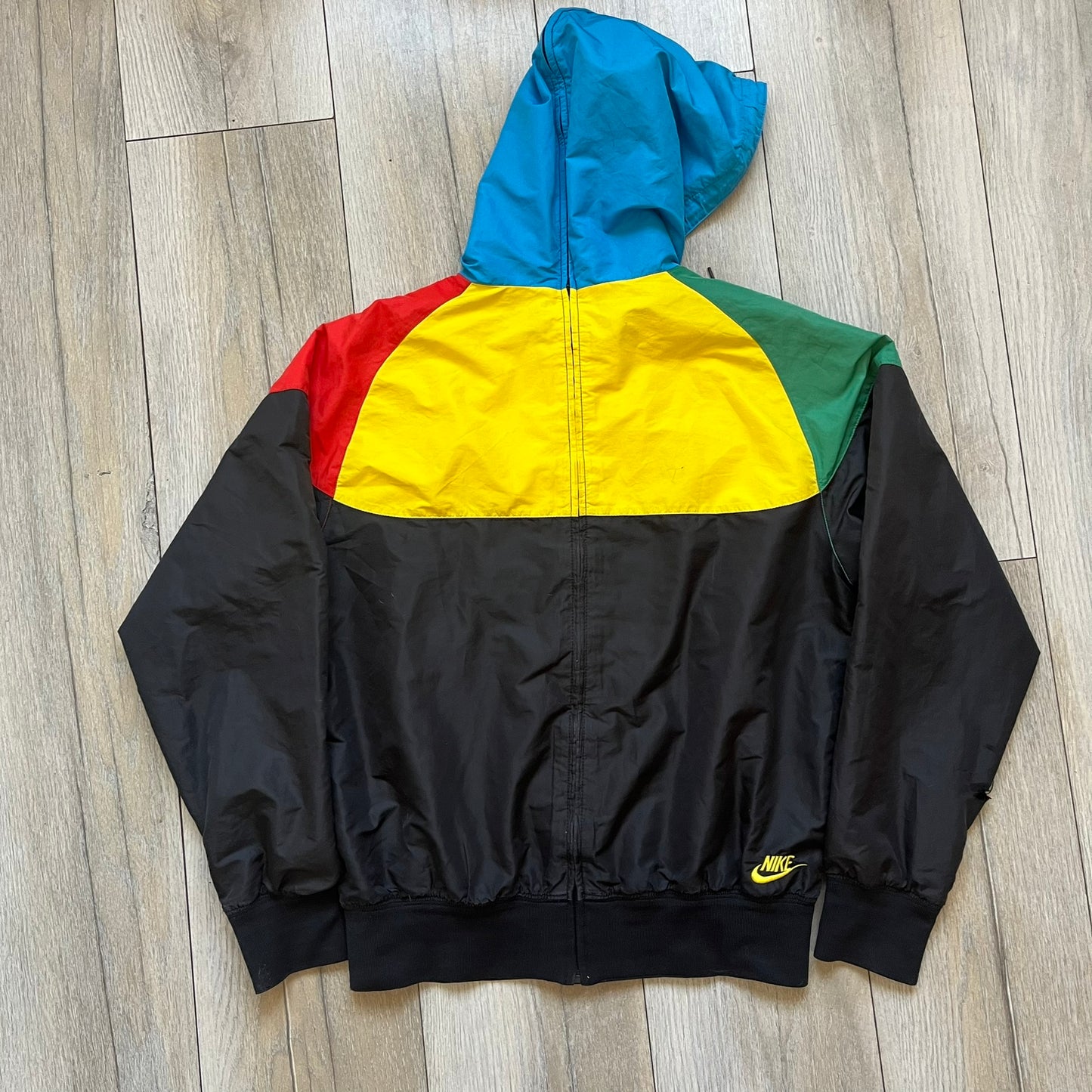 Nike Ethiopia Olympics 2008 Split Windbreaker is a performance jacket designed by Jarrett Reynolds for the Olympic collection. The jacket features a black lower section, yellow upper body, blue hood, green shoulder and red opposite shoulder. The chest is finished with an embroidered Nike logo and Ethiopia emblem. The jacket features a unique split construction that allows it to be unzipped along both sides and connected with other compatible jackets. Hidden inside, a small Ethiopia flags accent completes th