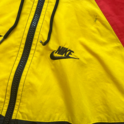 Nike Ethiopia Olympics 2008 Split Windbreaker is a performance jacket designed by Jarrett Reynolds for the Olympic collection. The jacket features a black lower section, yellow upper body, blue hood, green shoulder and red opposite shoulder. The chest is finished with an embroidered Nike logo and Ethiopia emblem. The jacket features a unique split construction that allows it to be unzipped along both sides and connected with other compatible jackets. Hidden inside, a small Ethiopia flags accent completes th