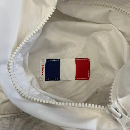 The Nike France Olympics 2008 Split Windbreaker made in a white, red, and navy color block representing France, it includes a red embroidered Nike logo and hidden French flags inside both pockets. It features a modular design by Jarrett Reynolds, allowing the jacket to split on both sides via dual zippers.