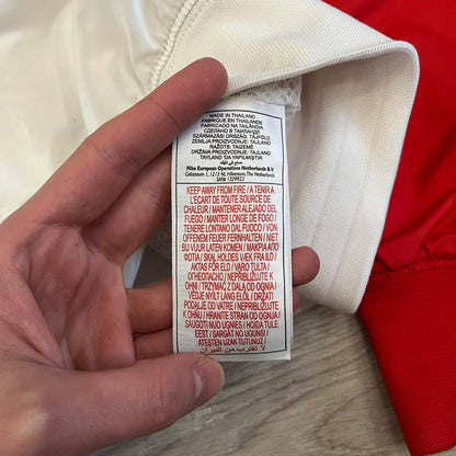 The Nike France Olympics 2008 Split Windbreaker made in a white, red, and navy color block representing France, it includes a red embroidered Nike logo and hidden French flags inside both pockets. It features a modular design by Jarrett Reynolds, allowing the jacket to split on both sides via dual zippers.
