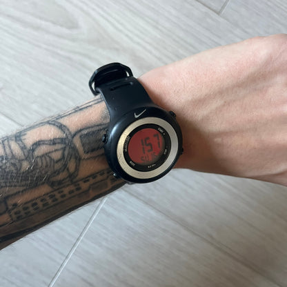Nike Georg WK0010 digital watch with a bold red dial and black case accented by a silver aluminum bezel. Features include chronograph, alarm, time, and date functions with a 12-hour display and backlight. Water-resistant up to 50m with a durable black silicone strap.