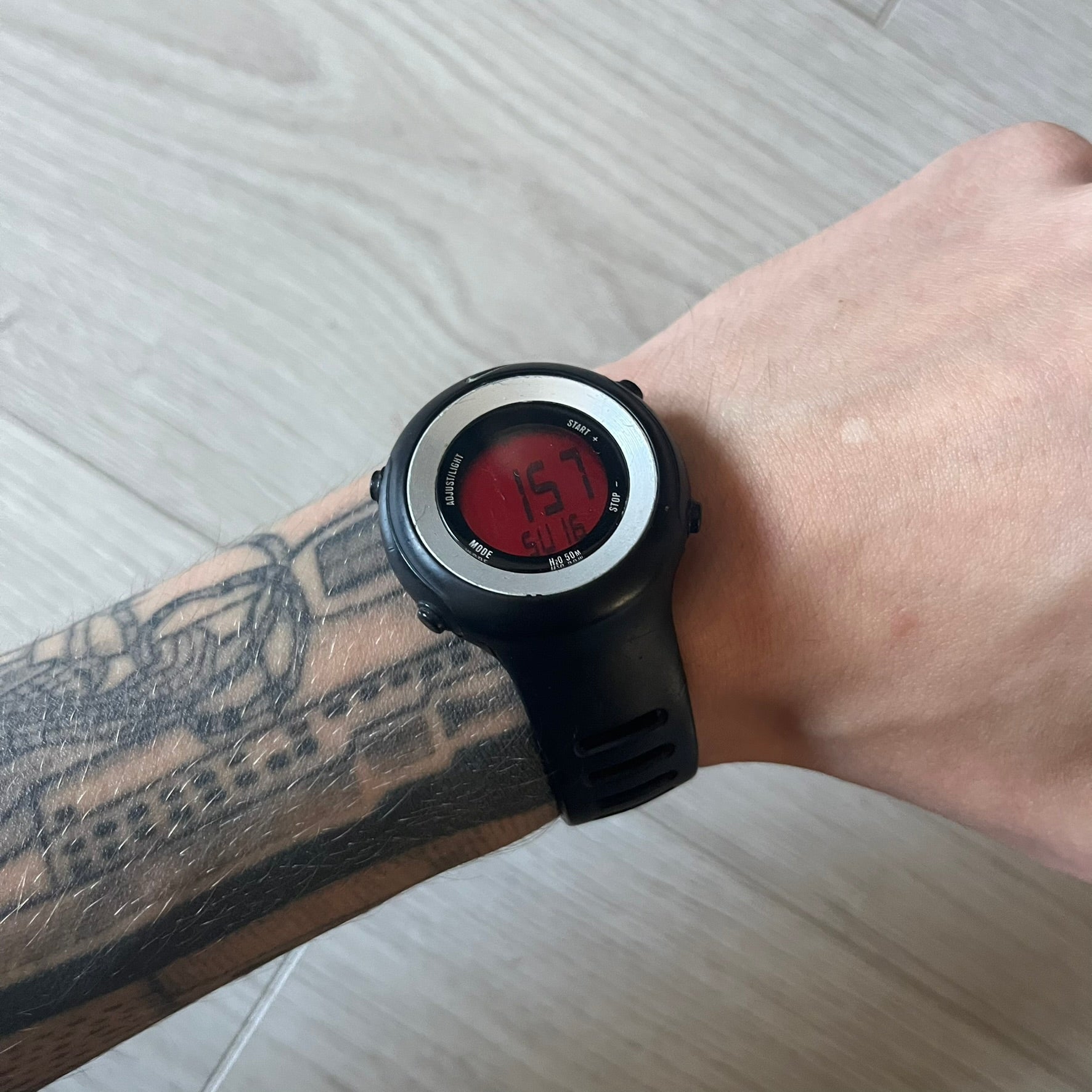 Nike Georg WK0010 digital watch with a bold red dial and black case accented by a silver aluminum bezel. Features include chronograph, alarm, time, and date functions with a 12-hour display and backlight. Water-resistant up to 50m with a durable black silicone strap.