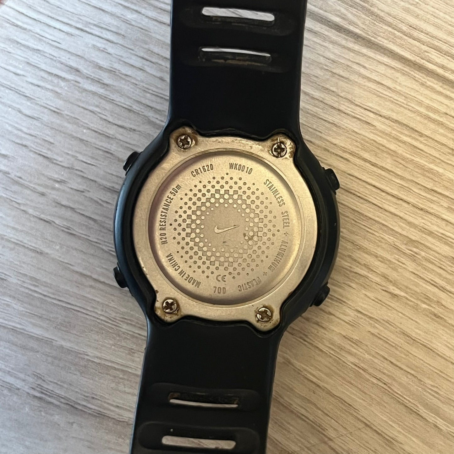Nike Georg WK0010 digital watch with a bold red dial and black case accented by a silver aluminum bezel. Features include chronograph, alarm, time, and date functions with a 12-hour display and backlight. Water-resistant up to 50m with a durable black silicone strap.