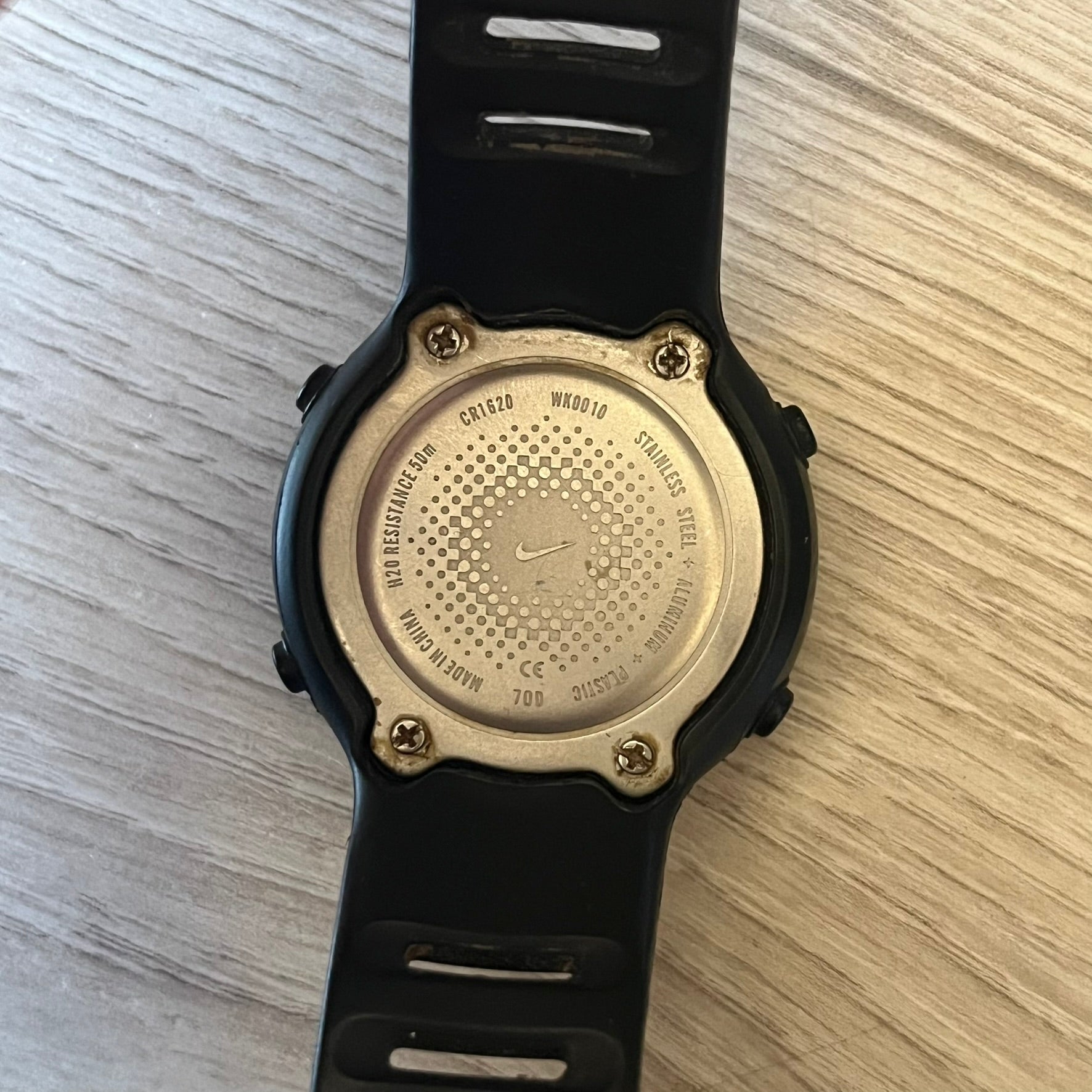 Nike Georg WK0010 digital watch with a bold red dial and black case accented by a silver aluminum bezel. Features include chronograph, alarm, time, and date functions with a 12-hour display and backlight. Water-resistant up to 50m with a durable black silicone strap.