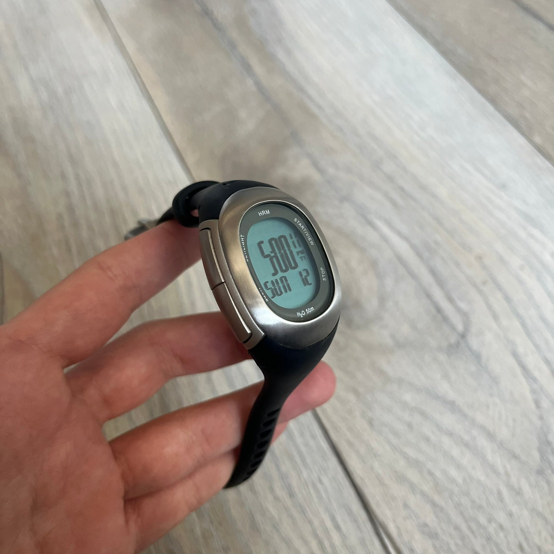 Nike Imara HRM SM0032 Digital Watch is a digital wristwatch featuring a silver case with gray-outlined display and a black rubber strap. The watch includes backlight functionality, multiple modes, and a chest heart rate monitor, with water resistance up to 59 meters. It comes with original box, papers, and a plastic store display.