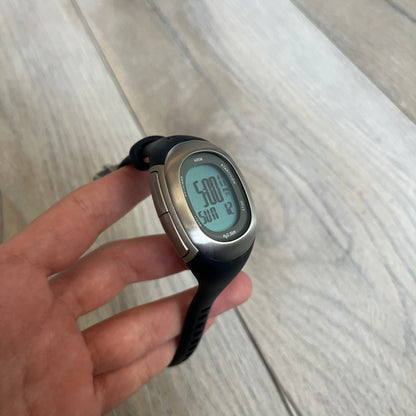 Nike Imara HRM SM0032 Digital Watch is a digital wristwatch featuring a silver case with gray-outlined display and a black rubber strap. The watch includes backlight functionality, multiple modes, and a chest heart rate monitor, with water resistance up to 59 meters. It comes with original box, papers, and a plastic store display.