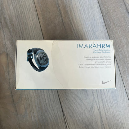 Nike Imara HRM SM0032 Digital Watch is a digital wristwatch featuring a silver case with gray-outlined display and a black rubber strap. The watch includes backlight functionality, multiple modes, and a chest heart rate monitor, with water resistance up to 59 meters. It comes with original box, papers, and a plastic store display.