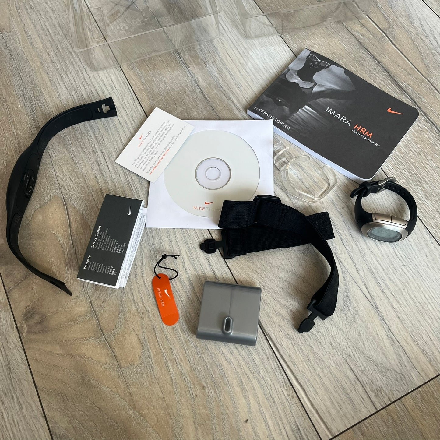 Nike Imara HRM SM0032 Digital Watch is a digital wristwatch featuring a silver case with gray-outlined display and a black rubber strap. The watch includes backlight functionality, multiple modes, and a chest heart rate monitor, with water resistance up to 59 meters. It comes with original box, papers, and a plastic store display.