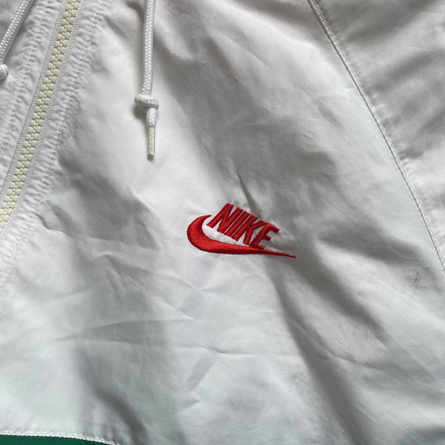 Nike Italy Olympics Split Windbreaker from 2008, created by designer Jarrett Reynolds. Crafted in green/white/red, with a green lower half of the front and sleeves, white upper half and red hood. This innovative jacket can be zipped apart on both sides and merged with other compatible models. Hidden inside, a small Italy flags accent completes the concept.
